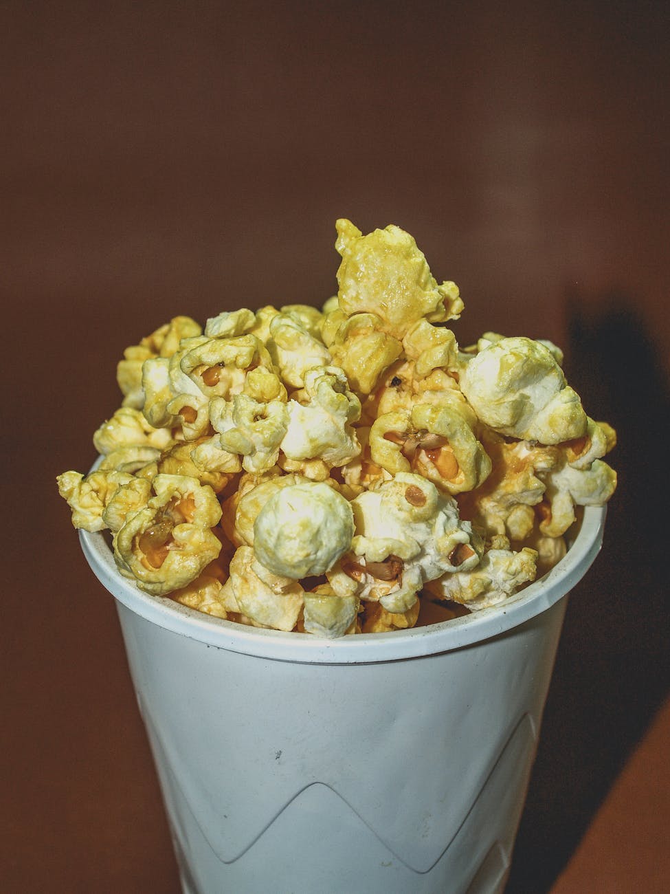 Family watching a movie together on a couch with popcorn.