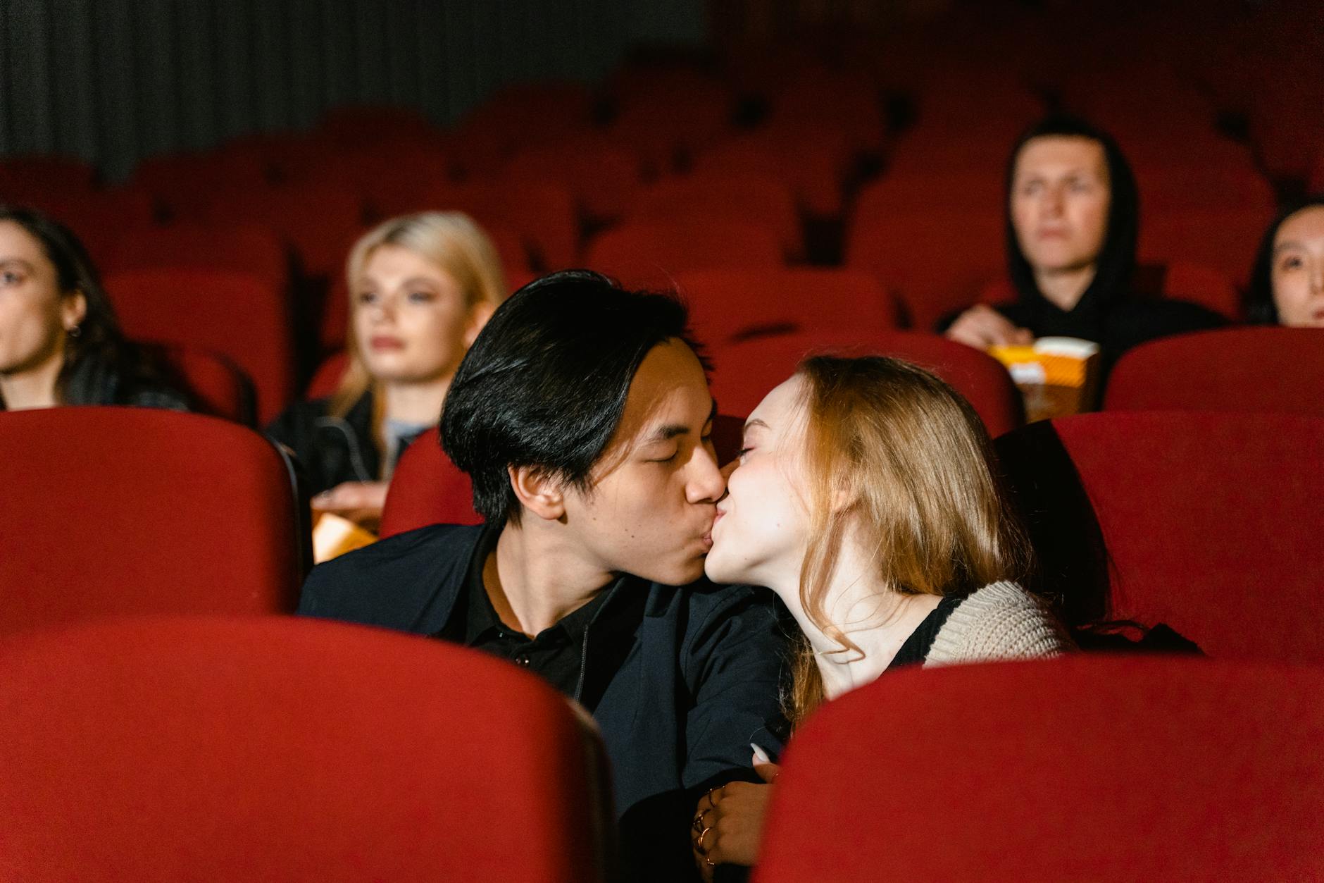 Couple embracing romantically under soft lighting.